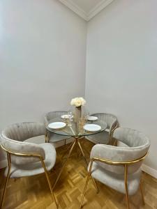 a dining room with a glass table and chairs at Bel appartement centre ville in Limoges