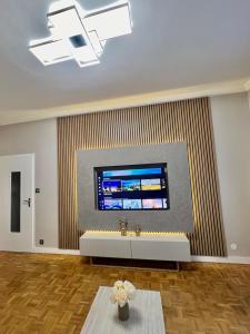a living room with a large tv on a wall at Bel appartement centre ville in Limoges