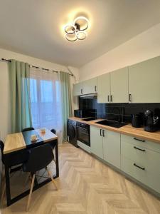 a kitchen with white cabinets and a table and a dining room at Bel appartement centre ville in Limoges