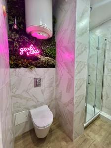 a bathroom with a toilet and a pink sign on the wall at Bel appartement centre ville in Limoges +4 photos