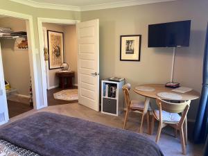 a room with a table and a tv and a table and chairs at The Red Letterbox in Blackheath
