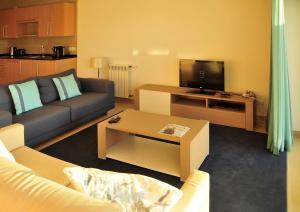 カザル・ダ・ラゴア・セッカにあるPraia Del Rey SeaView Dupplexのソファとテレビのあるリビングルーム