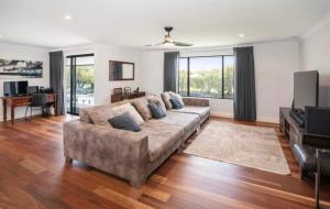 a living room with a couch and a television at Huge Luxury Busselton Jetty in Busselton