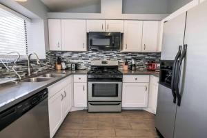 a kitchen with white cabinets and a stove and a sink at What you need A Hidden Gem in the Heart of Vegas in Las Vegas