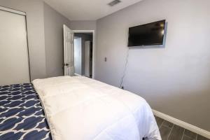 a bedroom with a white bed and a flat screen tv at What you need A Hidden Gem in the Heart of Vegas in Las Vegas