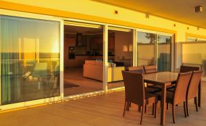 卡薩奧德拉戈雅塞加的住宿－Praia Del Rey SeaView Dupplex，一个带桌椅的阳台和一间客厅