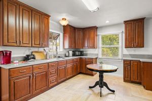 eine Küche mit Holzschränken und einem Tisch darin in der Unterkunft Spacious Retreat w Large Kitchen & Outdoor Patio in Pasadena