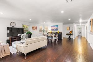 ein Wohnzimmer mit einer Couch, einem Fernseher und einem Tisch in der Unterkunft Spacious Retreat w Large Kitchen & Outdoor Patio in Pasadena