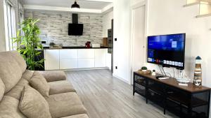 ein Wohnzimmer mit Sofa und Flachbildfernseher in der Unterkunft Duplex en la playa in Puerto Marino