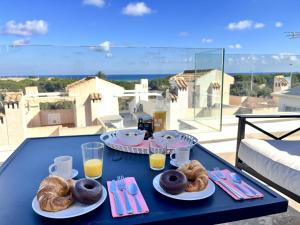 einen Tisch mit Teller mit Donuts und Gläsern Orangensaft in der Unterkunft Duplex en la playa in Puerto Marino