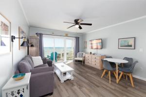 a living room with a couch and a table at Oceanfront Bliss at Wave Raider -Perfect Getaway in North Topsail Beach