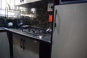 a kitchen with a stove and a refrigerator at Amangee Luxury Apartments in Jimeta +2 photos