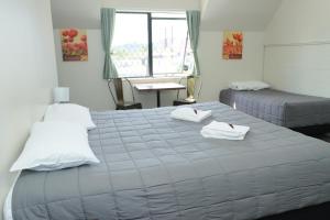 a bedroom with two beds with towels on them at Drury Motor Lodge in Drury