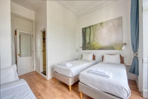 a white room with two beds and a chair at Monte da Lua in Sintra