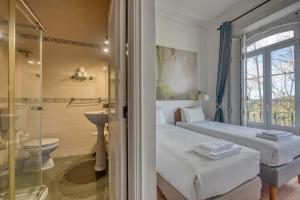 two beds in a room with a shower and a bathroom at Monte da Lua in Sintra