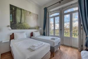 two beds in a room with a window at Monte da Lua in Sintra