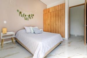 a bedroom with a bed and a wooden cabinet at Casa en Club Campestre frente a Campo de Golf in Cali +34 photos