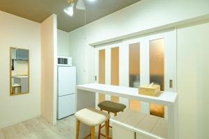 a kitchen with a counter and two stools at CREARE Residence Kagurazaka - クレアーレ神楽坂ゲストハウス105号室 in Tokyo