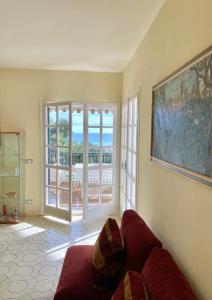 a living room with a couch and a large window at Un posto al Sole, Bordighera in Bordighera