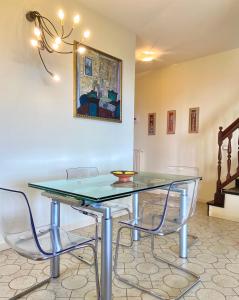 a dining room with a glass table and chairs at Un posto al Sole, Bordighera in Bordighera