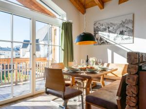 Un comedor con una mesa y un gran ventanal. en Tauernsuites Mitterwirt TOP 322, en Piesendorf