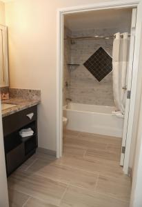 a bathroom with a tub and a toilet and a sink at Grand Legacy At The Park in Anaheim