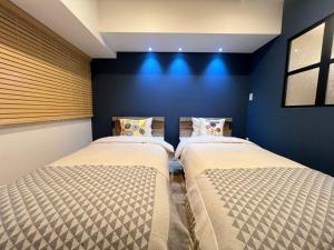 two beds in a room with blue walls at World House Kameido -Direct to Akihabara&Shinjuku, near Asakusa &Skytree, 30 mins to Disney by train in Tokyo +79 photos