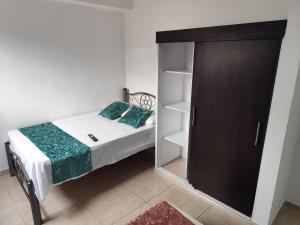 a small bedroom with a bed and a closet at Wil Hostal Apt 203 in Cali