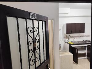 a door with a sign on it in a kitchen at Wil Hostal Apt 203 in Cali