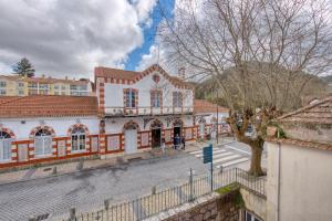 a building with a tree in front of a street at Monte da Lua in Sintra