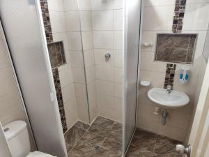 a bathroom with a shower and a toilet and a sink at Edificio Wil Hostal Apt 203 in Cali +5 photos