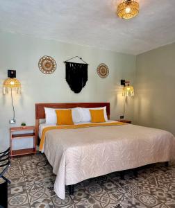 a bedroom with a large bed and two lamps at CASA VICTORIA in Chichén-Itzá