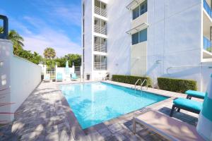 布卡拉顿Stylish 2BR, 2BA Apartment with Balcony & Pool - Just Steps from the Beach的建筑物前的游泳池
