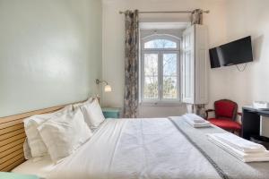 a bedroom with a white bed and a window at Monte da Lua in Sintra