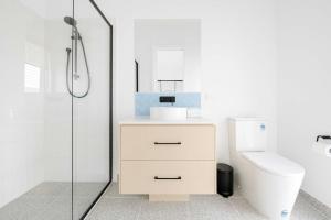 a bathroom with a toilet and a glass shower at Torquay Beach Getaway in Torquay +27 photos