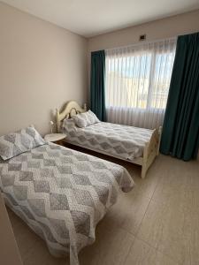 een slaapkamer met twee bedden en een raam bij Departamento Luz in Plottier