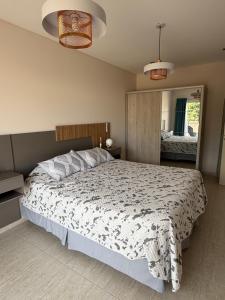 een slaapkamer met een bed en een grote spiegel bij Departamento Luz in Plottier