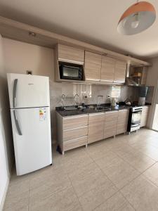 een keuken met een witte koelkast en een spoelbak bij Departamento Luz in Plottier
