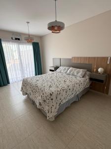 een slaapkamer met een bed met een zwart-wit dekbed bij Departamento Luz in Plottier