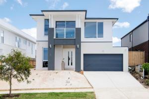 a white house with a garage at Torquay Beach Getaway in Torquay