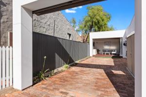 einen externen Eingang zu einem Haus mit einem Backsteingang in der Unterkunft Bluestone Symmetrical Cottage with Outdoor Area in North Adelaide