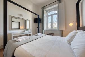 a bedroom with a white bed and a mirror at Monte da Lua in Sintra