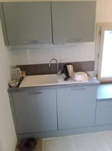 a kitchen with white cabinets and a sink at Maison conviviale avec jardin à Raslay, 80 m² in Raslay