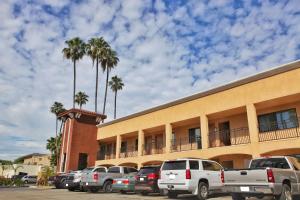 a parking lot in front of a building with palm trees at Grand Legacy At The Park in Anaheim