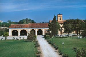 a large building with a clock tower in a field at Tenuta Le Sorgive Agriturismo in Solferino
