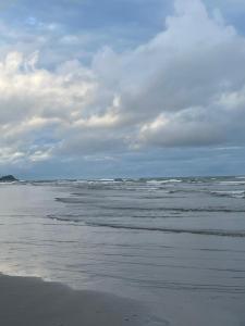 ein Strand mit dem Meer an einem bewölkten Tag in der Unterkunft Cantinho da serra do Guaraú in Peruíbe