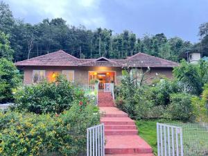a house with a staircase leading to a garden at Nila Homestay in Puliyara