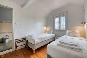 two beds in a room with a mirror and a sink at Monte da Lua in Sintra