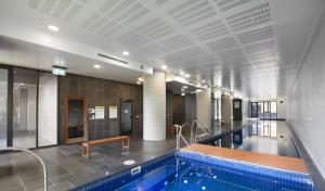 a swimming pool in a large building with a swimming pool at Zen Grand 3 Bedroom Residences 120m2 with up to 7 Separate Beds in Melbourne