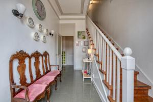 a hallway with chairs and stairs with a clock on the wall at Monte da Lua in Sintra